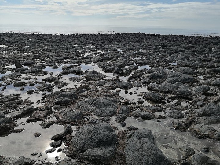 Pantai Batu Hitam berbatu hitam di Kuantan semasa air surut